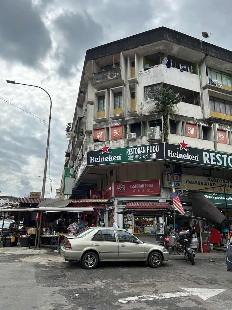 A corner Coffeeshop with small trader stalls in front of the restaurant 