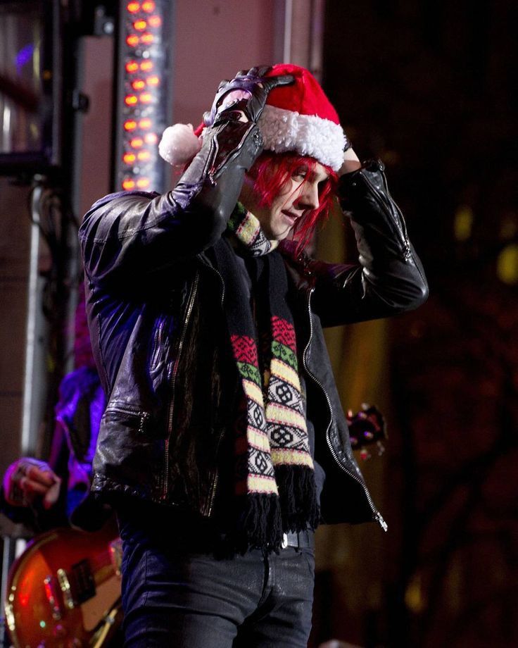 Photo of Gerard Way from My Chemical Romance (MCR) wearing a black leather jacket, black gloves, Christmas scarf and a santa hat