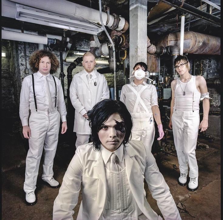 Photo of Ray Toro, Bob Bryar, Gerard Way, Frank Iero and Mikey Way from My Chemical Romance (MCR). they're all wearing white clothes with four of them standing in the back while Gerard is sitting in the front. 
