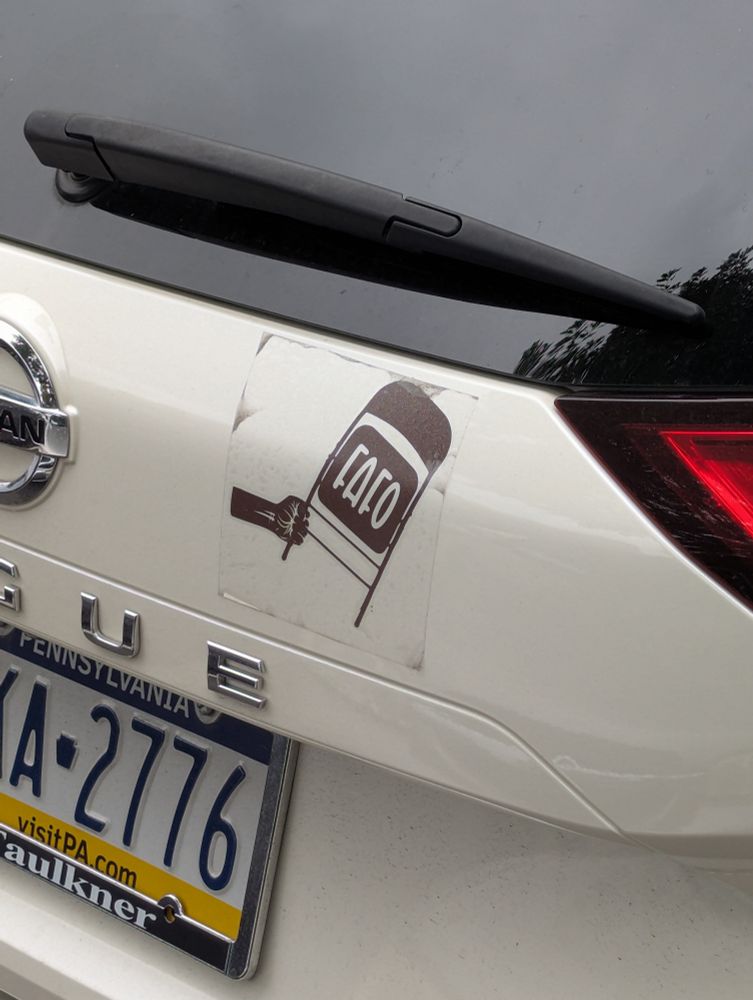 The back of an SUV with a bumper sticker of a Black fist holding a folding chair with "FAFO" on it. 
