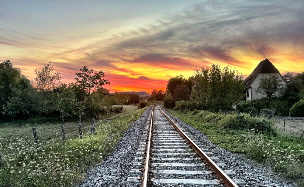 Looking straight along a railway line towards a fiery sunset