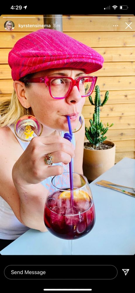 kyrsten sinema making a cute face while drinking from a straw as she drops a complete idiot hell fucker take on social media