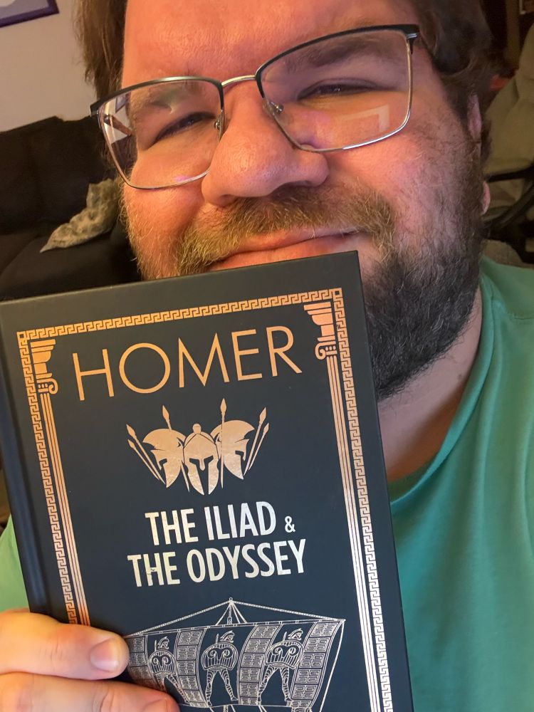 Me holding a copy of the Iliad and the Odyssey