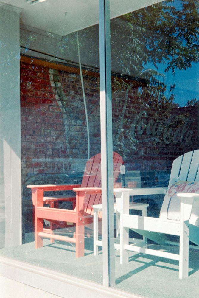 Two Chairs.  Two chairs in a display window in bright sunlight.  Same store as the Bassett sign.  Sanford North Carolina.