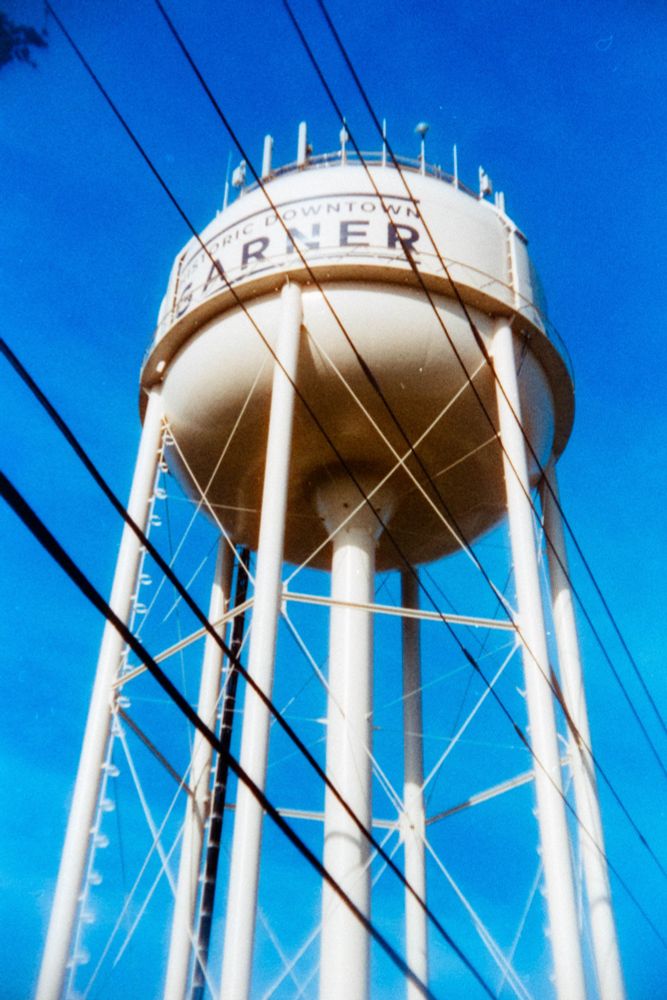 And what visit to downtown Garner doesn't include a picture of the Garner watertower.  Which is actually part of the Raleigh NC water system.  Raleigh provides water to Garner.   The watertower doubles as a wireless tower, please note the antennae on the top of the tank.   
Shot 7 December 2024 on Harmon Phoenix 200 shot at an EI of 125 ISO on an Argus A2F probably at f/18 at an indicated 1/100th. 