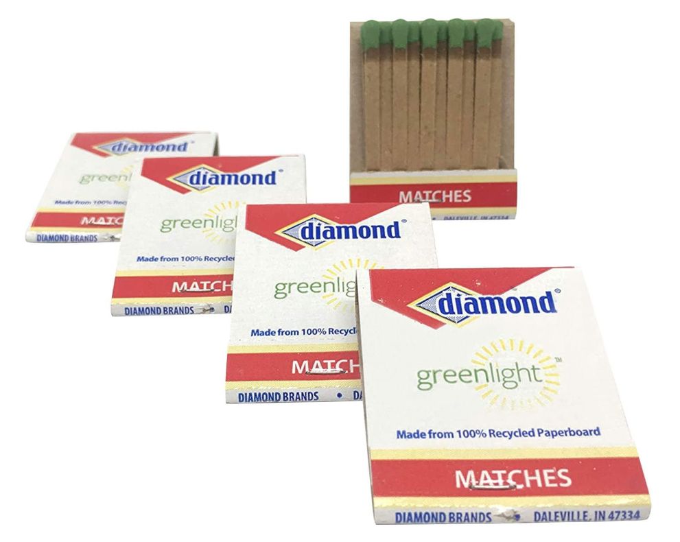 Diamond matchbooks in a line, with one open showing the green-headed matches inside