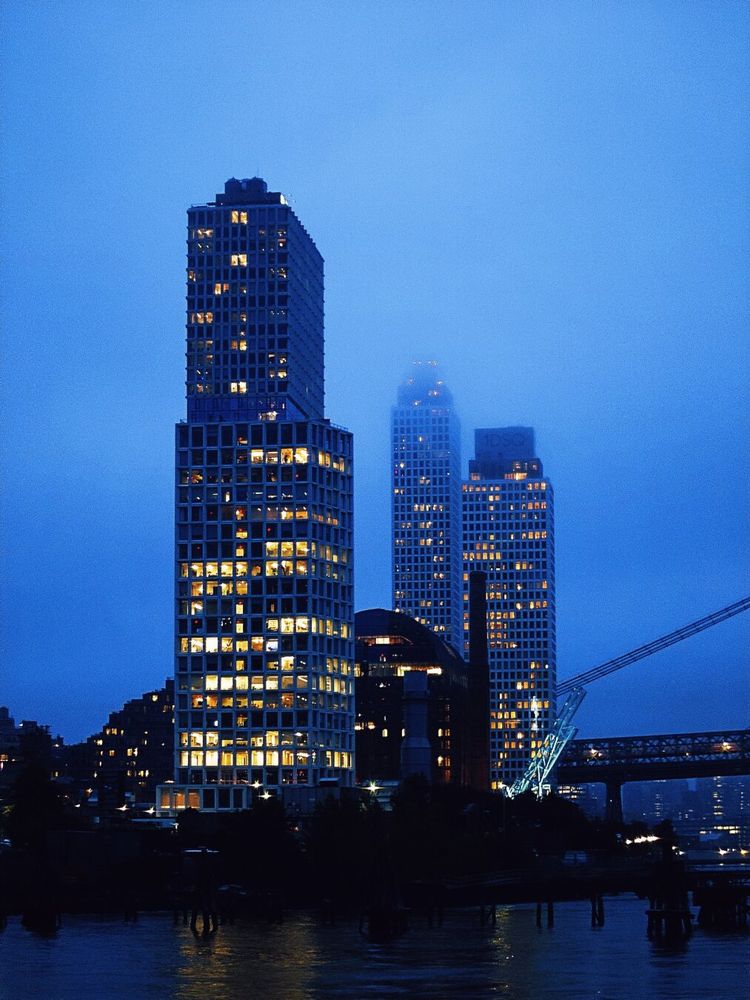Fog-shrouded high rises at dusk in shades of blue and orange