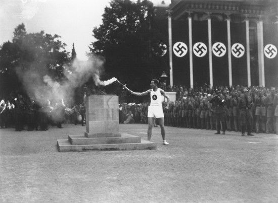 Picture of Olympic torch lighting Berlin 1936 with swastika flags in background