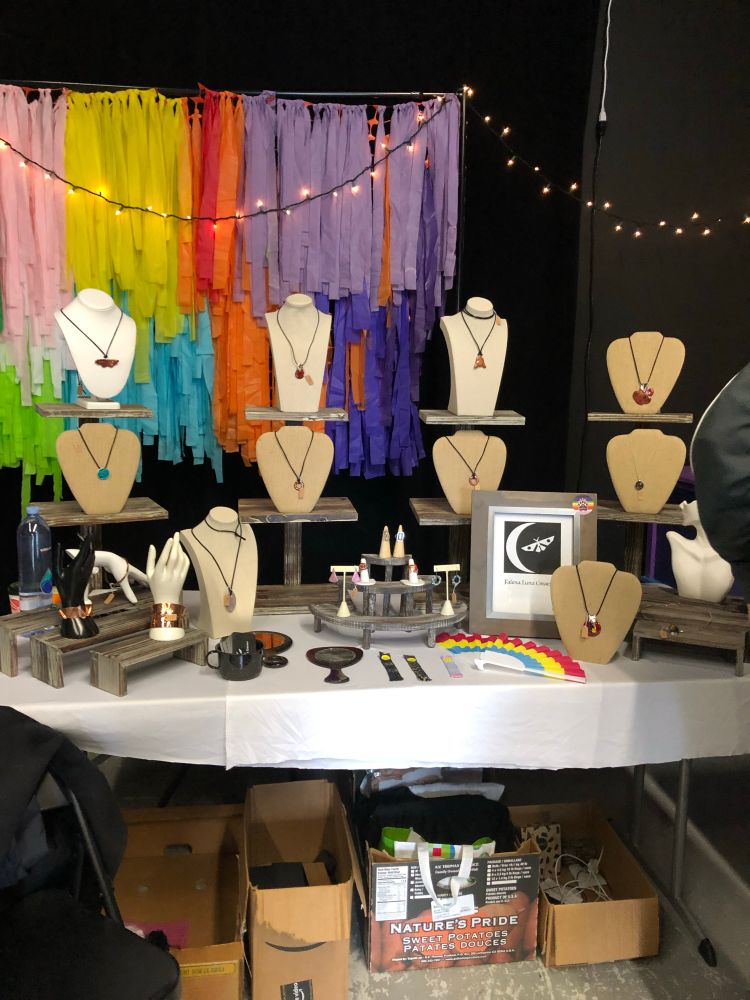 Display of Falena Luna Creations’ jewelry booth at an arts and crafts fair.
