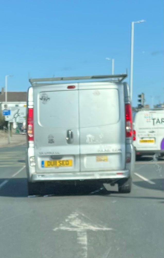 A builder’s van with the number plate DU11 SEO