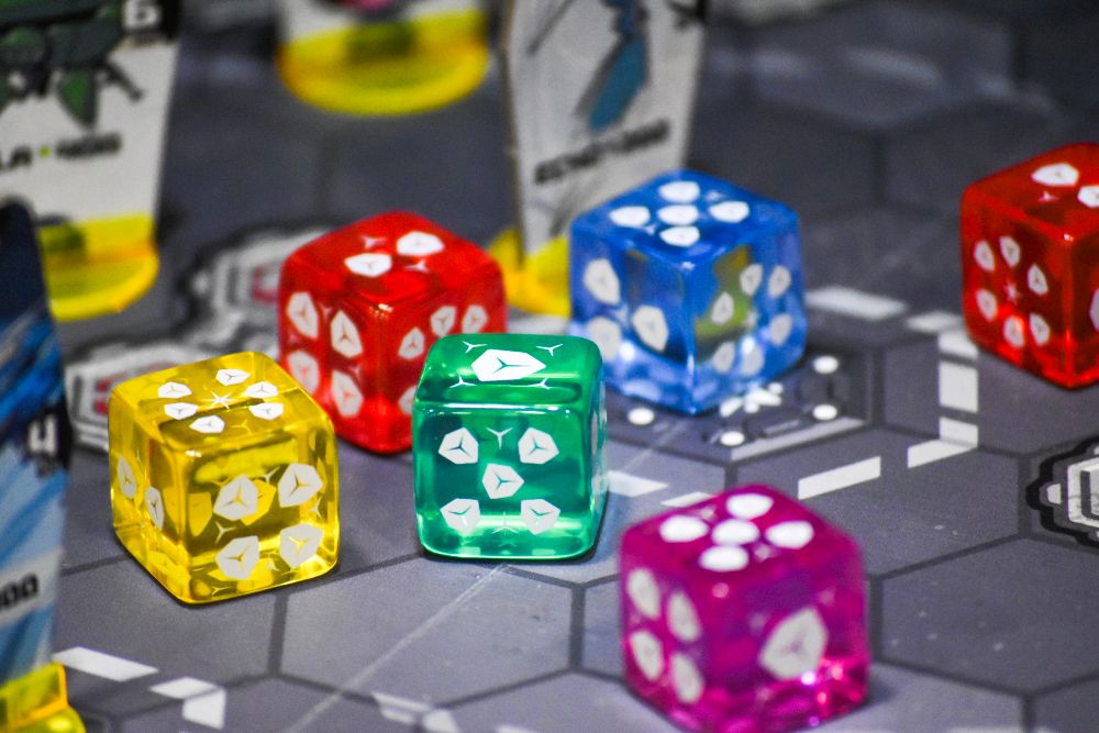 Photograph of the game AEGIS combining robots featuring several multicolored dice that look like Jolly Ranchers