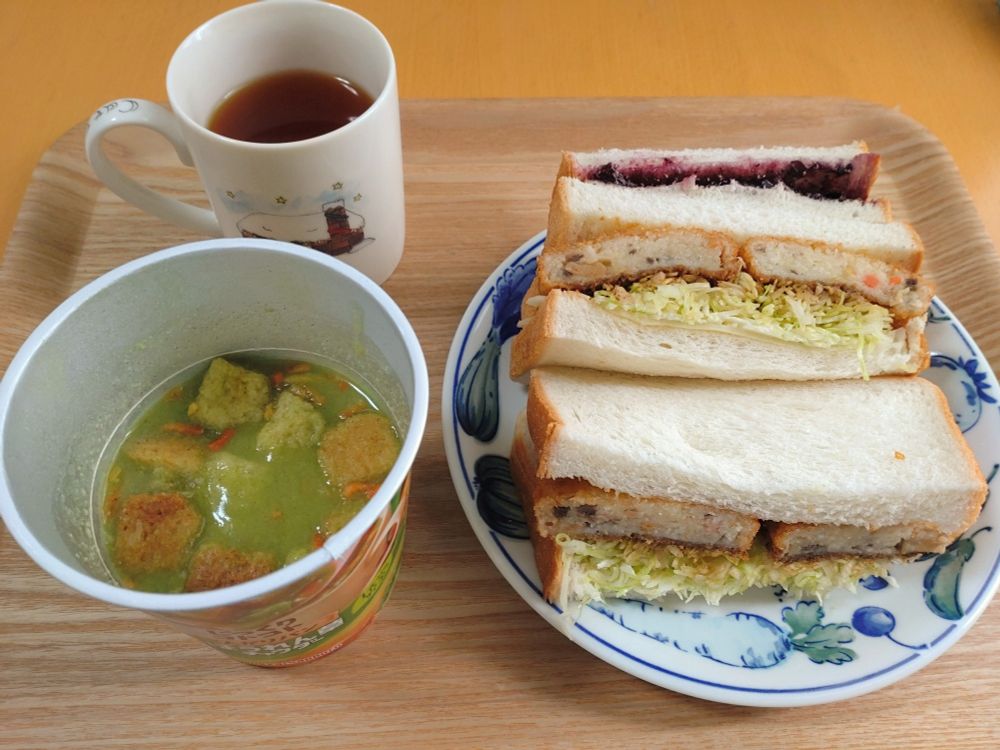 カップスープとコロッケのサンドイッチ2つに、ブルーベリージャムのサンドイッチ。マグカップの中は麦茶。