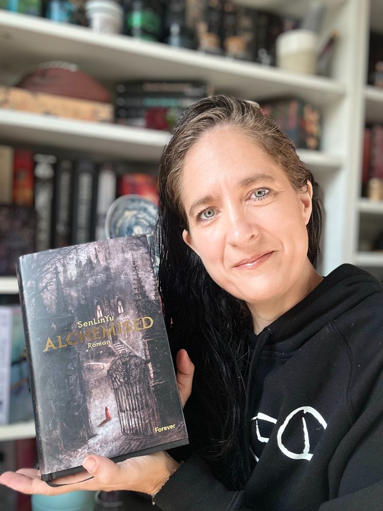 Ich halte meine deutsche Ausgabe von Alchemised vor meinem Bücherregal in meinen Händen und schaue dabei in die Kamera.

Nur das Cover des Buchs ist sichtbar.