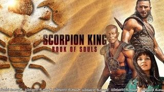A promotional image for the movie Scorpion King: Book of Souls, the fifth movie in the franchies, shows a stylized scorpion log at left, and three of the actors at right. The are a tanned white dude in some kind of armor, a bald Black dude wearing a sort of battle harness, and a woman with bronzed skin who is really committed to her bangs.