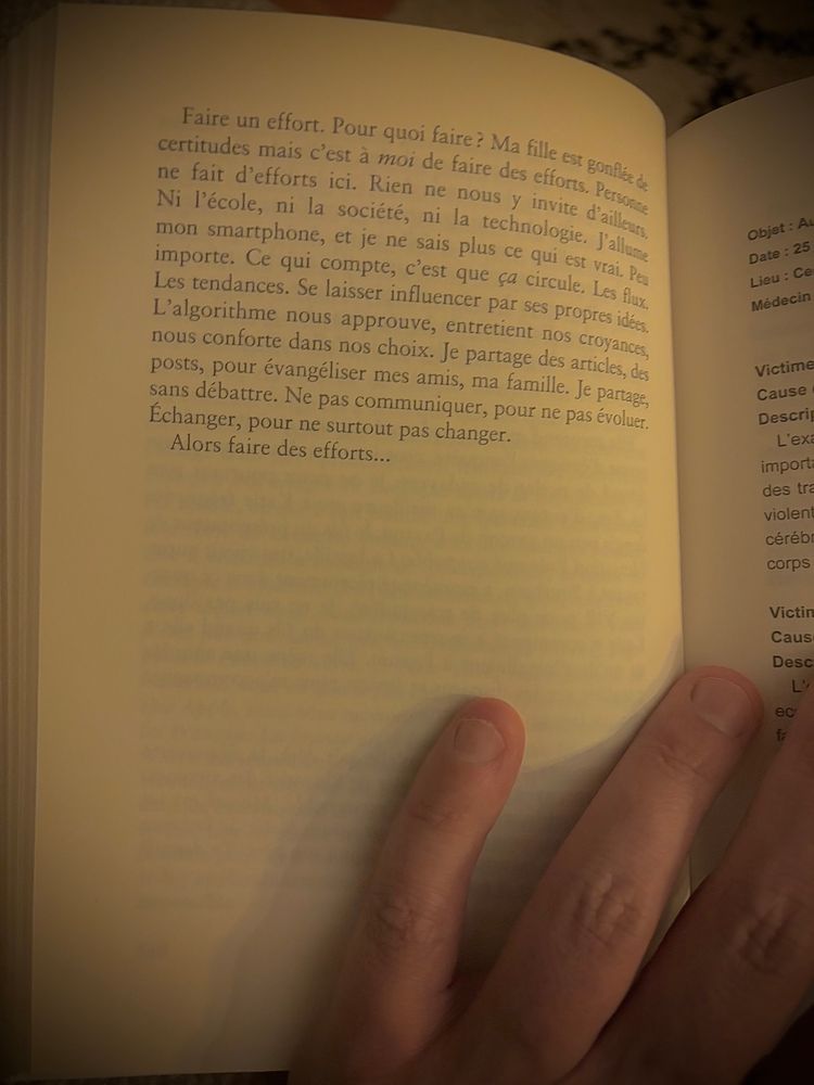 Un gros plan d’une page d’un livre, photographié sous une lumière chaude et tamisée, probablement en intérieur en soirée. Deux doigts d’une main — vraisemblablement celle de la personne qui lit — maintiennent la page ouverte. Le texte est en français et occupe le centre de la page de gauche, avec des paragraphes clairs et aérés. À droite, une autre page est partiellement visible avec des titres en gras (peut-être une fiche ou une note de synthèse). L’ambiance est intime, presque méditative, comme un moment volé au chaos pour lire quelques lignes percutantes.

Texte retranscrit :

Faire un effort. Pour quoi faire ? Ma fille est gonflée de certitudes mais c’est à moi de faire des efforts. Personne ne fait d’efforts ici. Rien ne nous y invite d’ailleurs.
Ni l’école, ni la société, ni la technologie. J’allume mon smartphone, et je ne sais plus ce qui est vrai. Peu importe. Ce qui compte, c’est que ça circule. Les flux. Les tendances. Se laisser influencer par ses propres idées,
L’algorithme nous approuve, entretient nos croyances, nous conforte dans nos choix. Je partage des articles, des posts, pour évangéliser mes amis, ma famille. Je partage, sans débattre. Ne pas communiquer, pour ne pas évoluer.
Échanger, pour ne surtout pas changer.
Alors faire des efforts…
