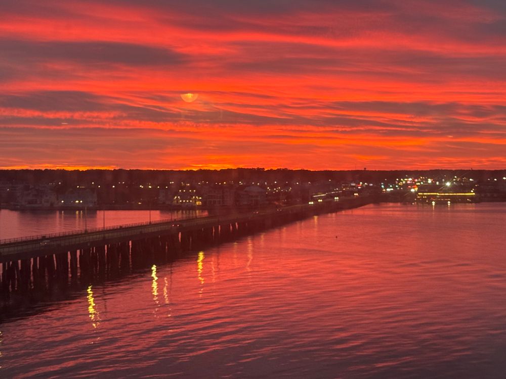 Vivid reds, oranges and purples in the sunset over the water in Ocean City, MD