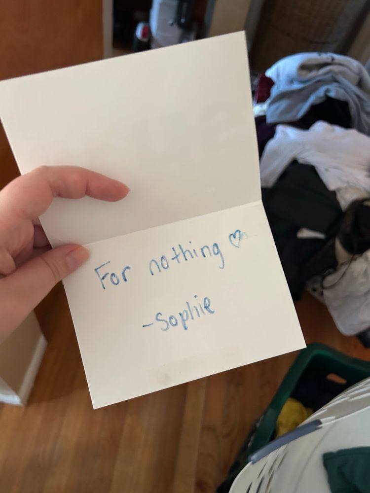The card is flipped open. It reads “For nothing. Heart. Sophie.”