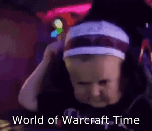 a baby is wearing a headband and a hat and says world of warcraft time .