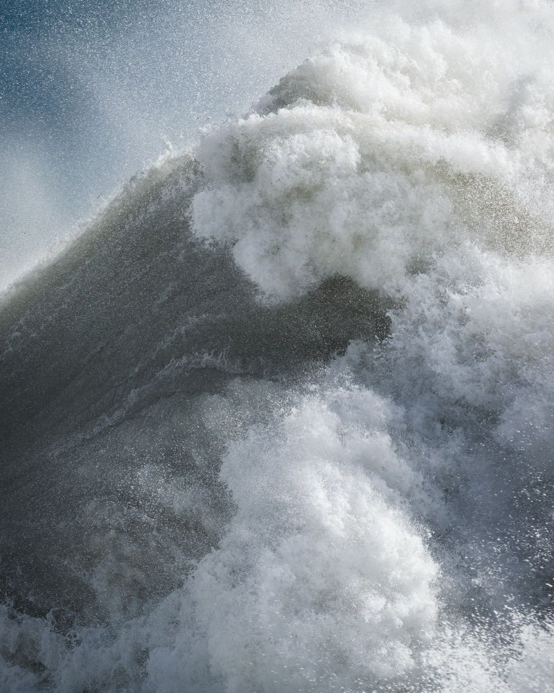 A fast-shutter, close-up photo of a wave. Sea foam and spray. 