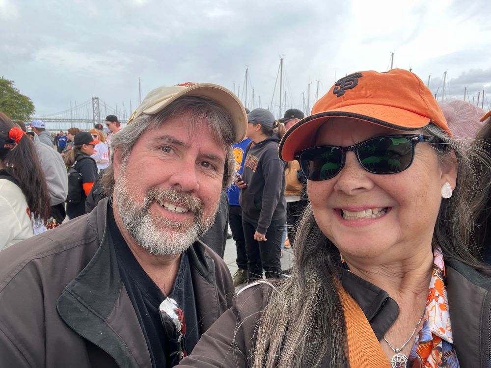 Two happy people wearing SF Giants hats