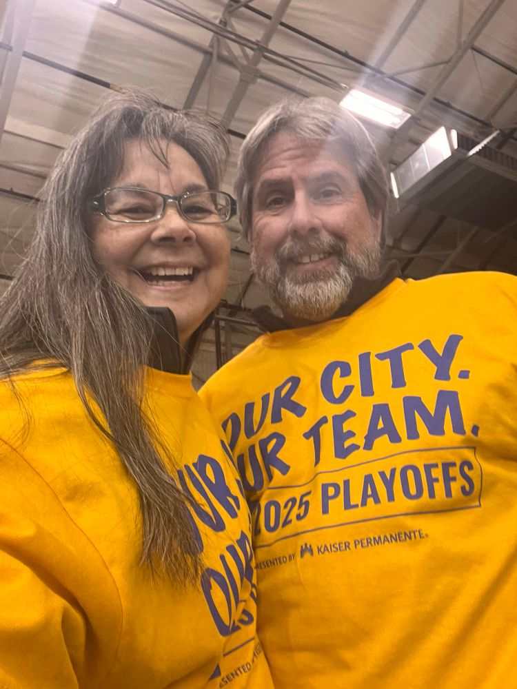 Two happy people with bright yellow shirts that read “our city, our team 2025 playoffs” 