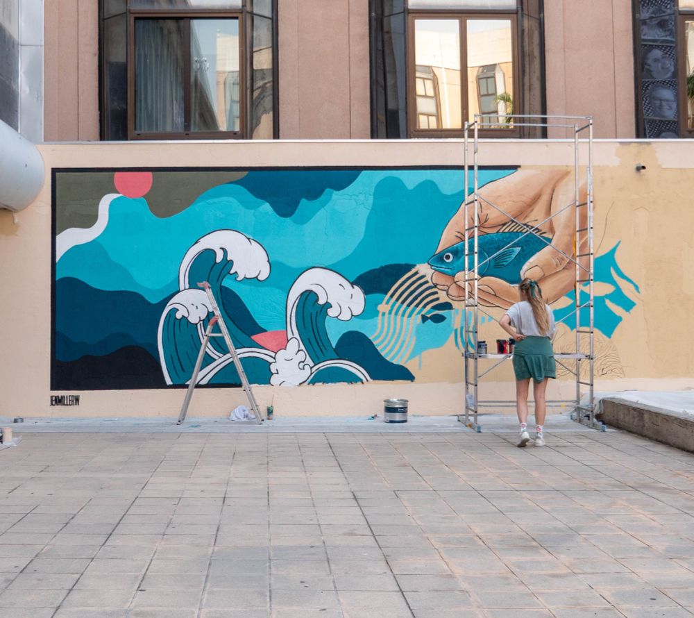 Mural artist Jen Miller painting entry wall.