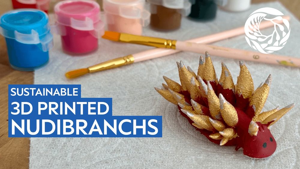 Sustainable 3D printed nudibranch art with brushes and paint in the background