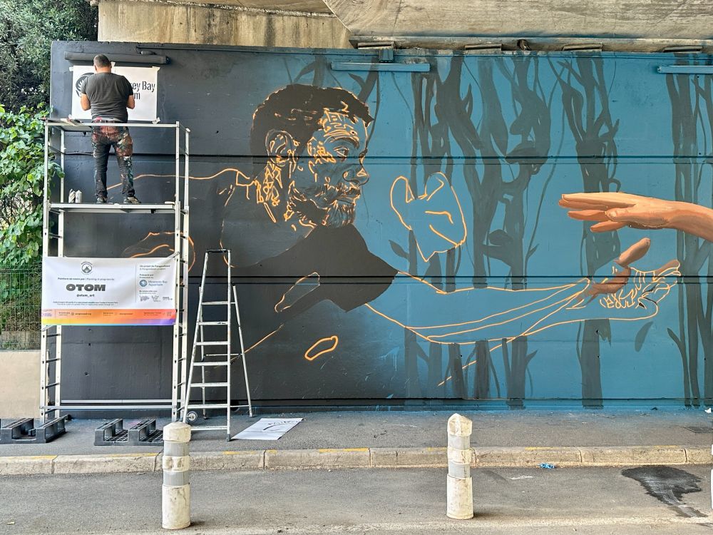 Mural artist Otom painting wall.