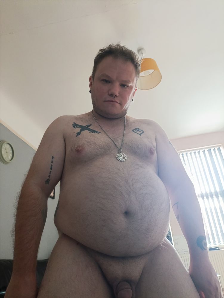 A chubby cub in his birthday suit showing off his growing belly 