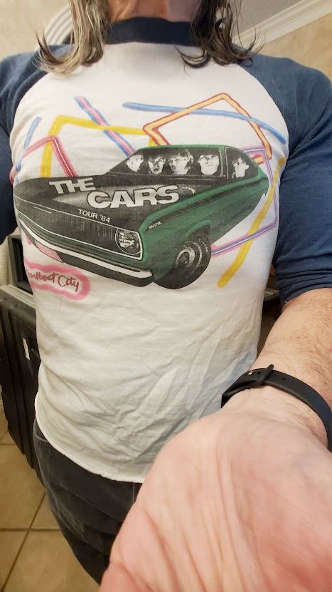 A man's torso, wearing a concert Tshirt for The Cars, Heartbeat City tour in 1984.