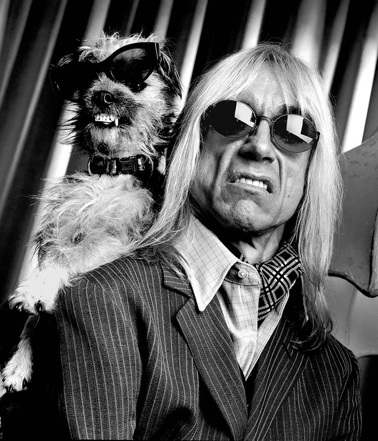 Iggy Pop with a dog showing teeth