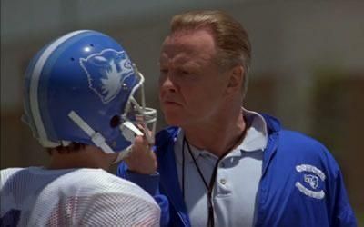 Actor Jon Voight grabs a player's helmet in the film Varsity Blues 