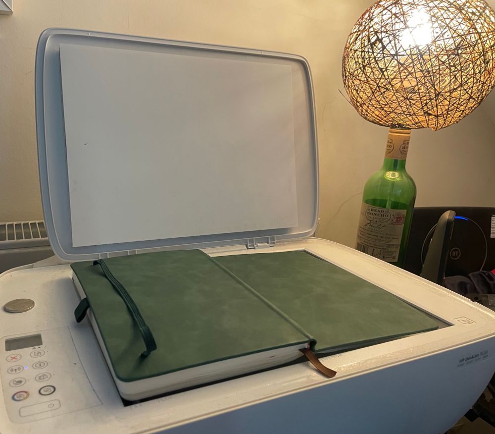 A scanner and a green notebook 
