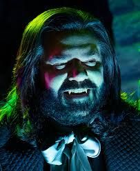 Laszlo from What We Do In The Shadows, grinning with pointed vampire teeth