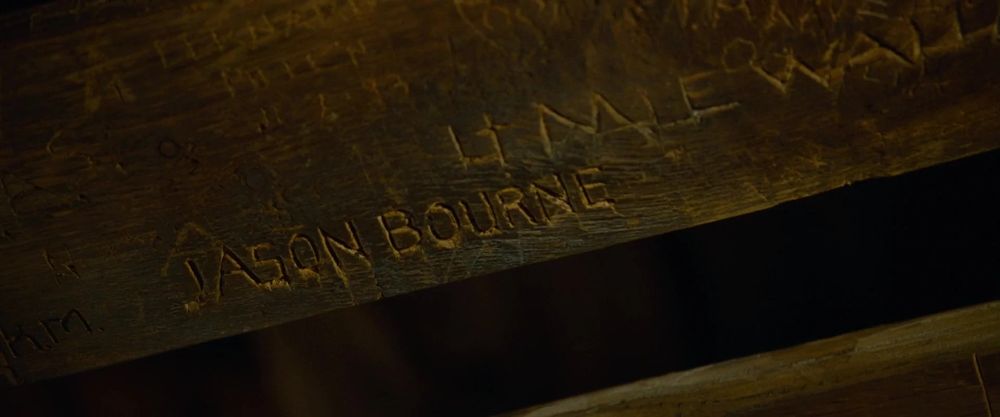 Jason Bourne's name carved under a bunk bed