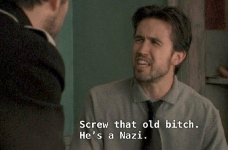 Screenshot from Always Sunny of Mac, a white Nan with brown hair and scruff, saying “screw that old bitch. He’s a Nazi.”