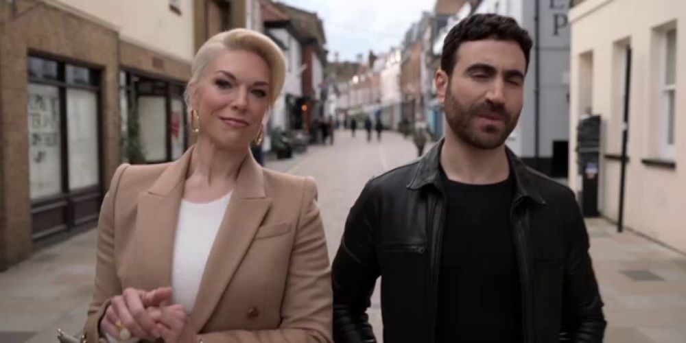 a man and a woman are walking down a street and the woman is wearing earrings