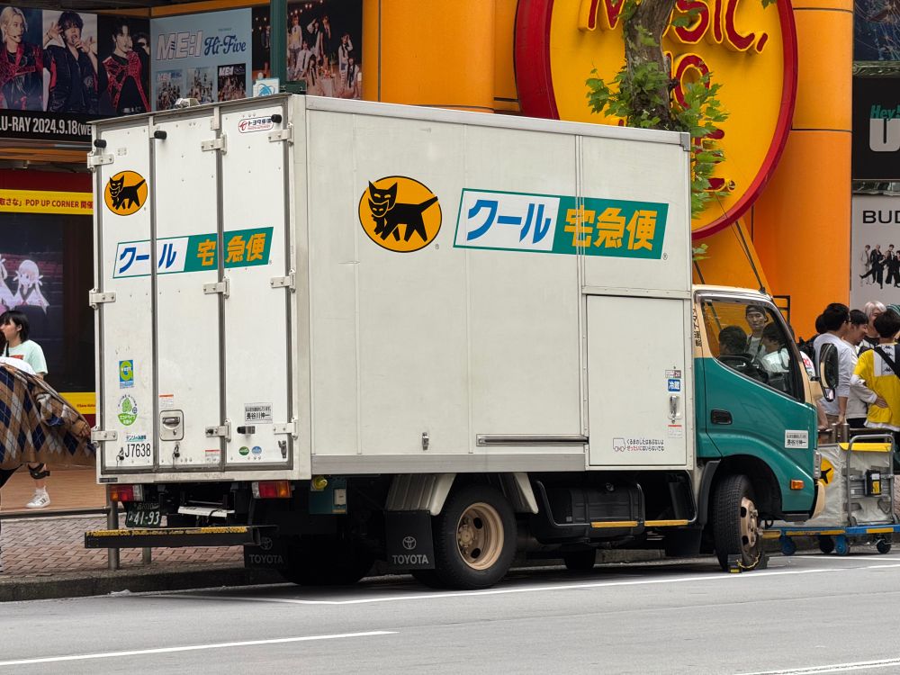 A Yamato delivery truck outside Tower Records in Tokyo, Japan. It is quite small for a truck, with its cab very close to the ground making it easier to drive in a big city with tiny streets