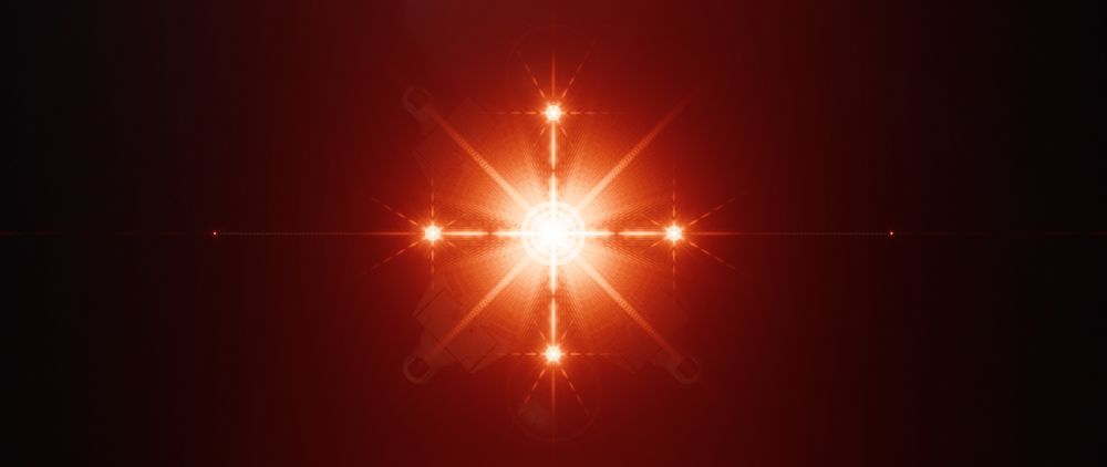 An enigmatic image showing five diffraction flares from the lasers of an unknown spaceship shining red light at the camera, the center one far larger than the four side ones. A fague silhouette of a ship is barely visible behind.