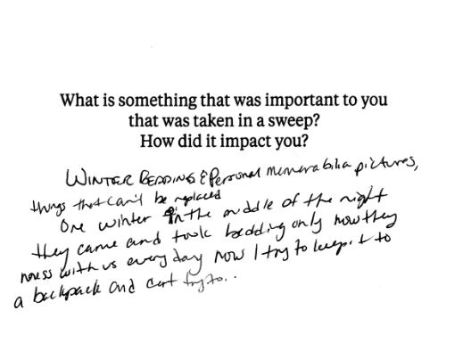 A notecard with the prompt, "What is something that was important to you that was taken in a sweep? How did it impact you?" The handwritten statement below says, “Winter bedding & personal memorabilia pictures, things that can’t be replaced. One winter in the middle of the night they came and took bedding only now they mess with us every day now I try to keep it to a backpack and cart try to.”