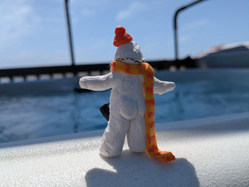 Backside view of a miniature Otto the Abominable Snow Dancer, standing at the edge of a hot tub