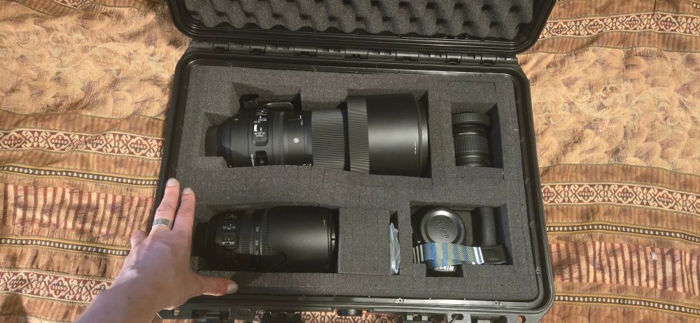 An opened MAXIMUM waterproof & dustproof case featuring a; Sigma 150mm-600mm Nikon Lense, 75mm-300mm Nikon Lense & Nikon 18mm-55mm Lense with a Nikon d3500 body.