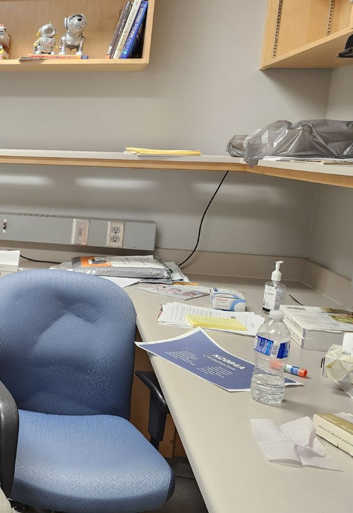 Photo of a dull, unkempt office. An old office chair with some scattered paper, empty water bottle and random items on the work area.