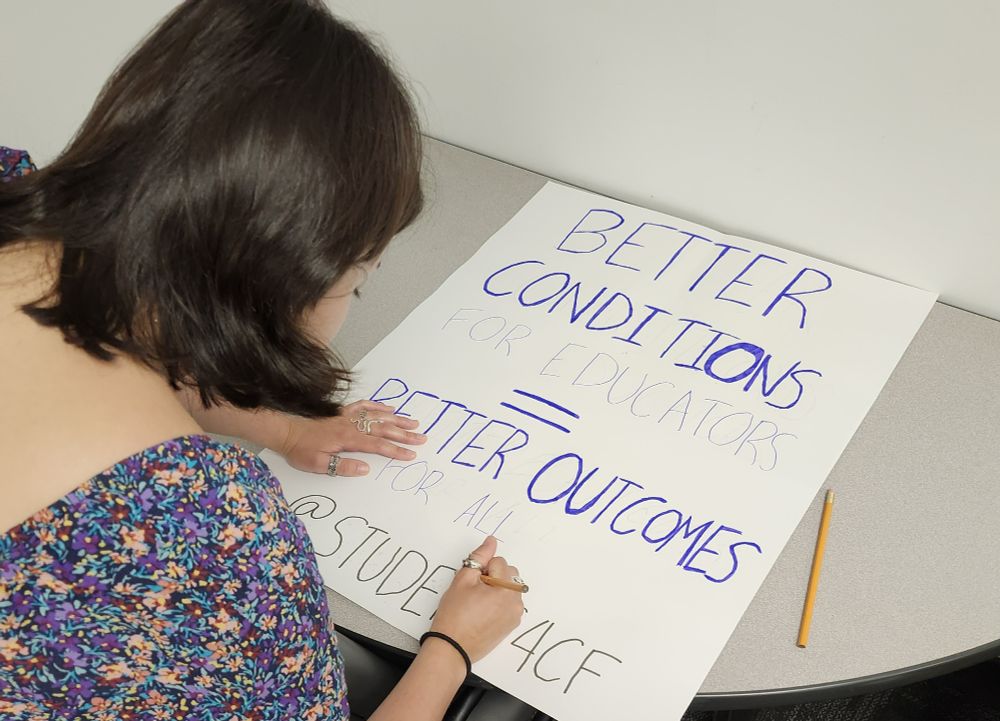 A student making a support sign