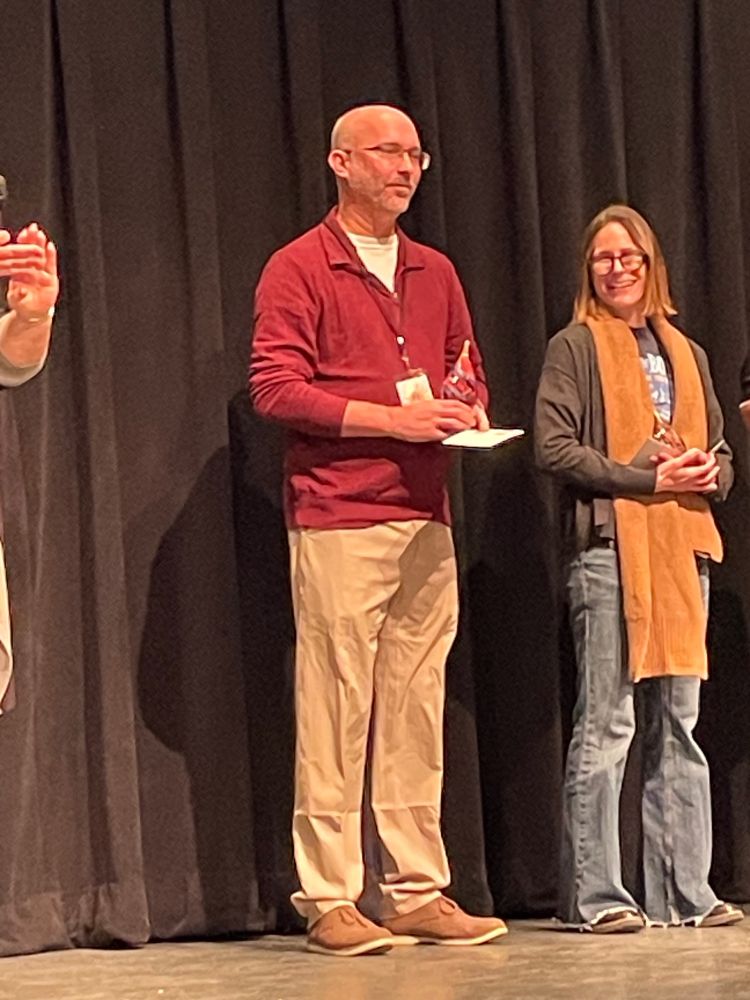 Jeremy Schnieder holding his teaching award. 
