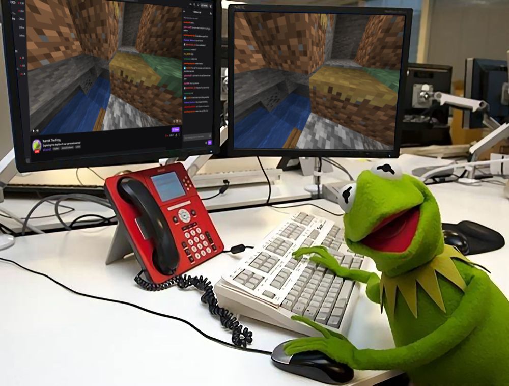 Kermit the frog at a dual monitor computer. Both monitors are square, with one showing a screnshot of Minecraft, and another showing the Twitch.tv stream of his gameplay and the chat box. Kermit himself is turned towards the camera, and is relatively pleased.