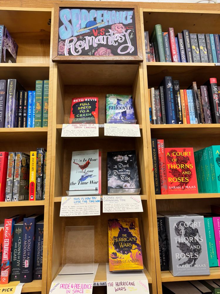 Bookcase at Powell’s Books on Hawthorne featuring the Spacemance versus Romantasy book display, including the titles “This is How You Lose the Time War” and “Full Speed to a Crash Landing.”