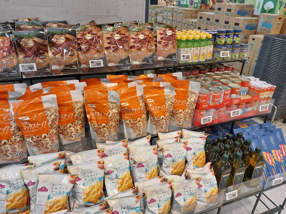 rows of dry sausage, lemon juice, pesto, olive oil, spaghetti, canned tomato, tortilla chips and nuts