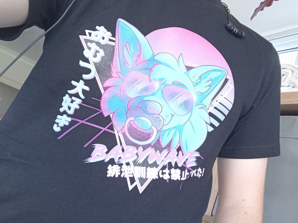 A cool retro looking vaporwave shirt with vibrant blues and purples and pinks. It's a picture of a super cool furry with shades on and a pacifier on its maw. It has what I believe is Japanese text at the side and bottom and then the text "babywave" in a scratchy font.