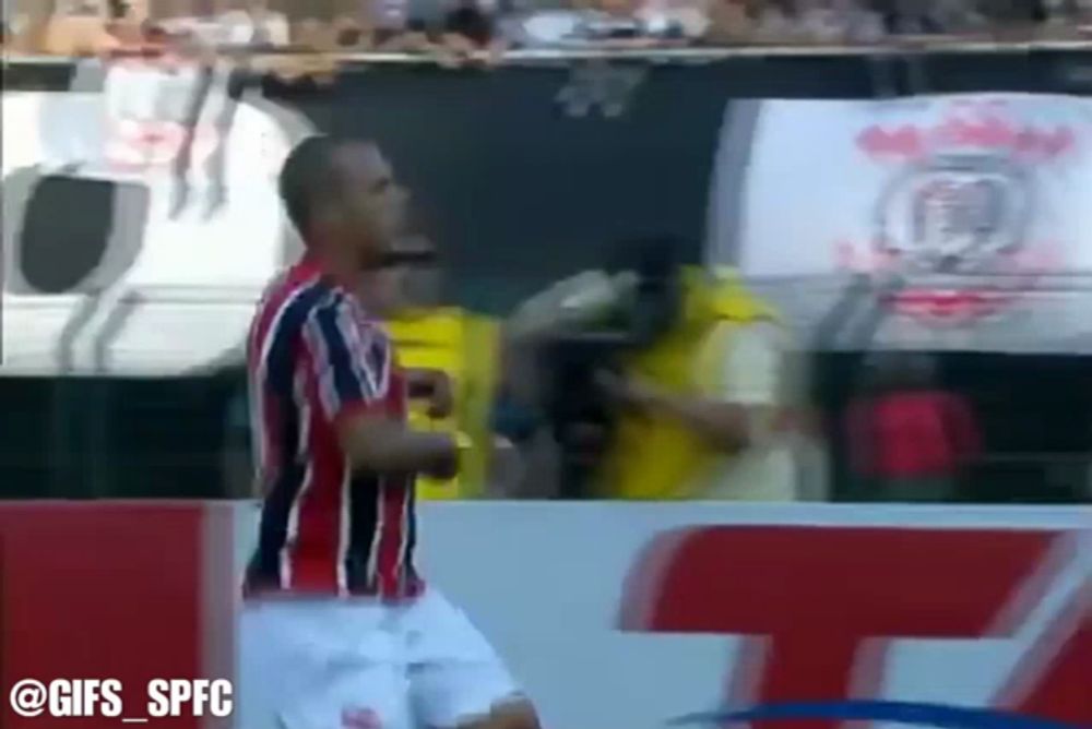 a soccer player in a red black and white jersey stands in front of a crowd